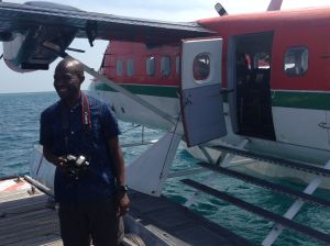 Jay standing by a seaplane, camera in hand